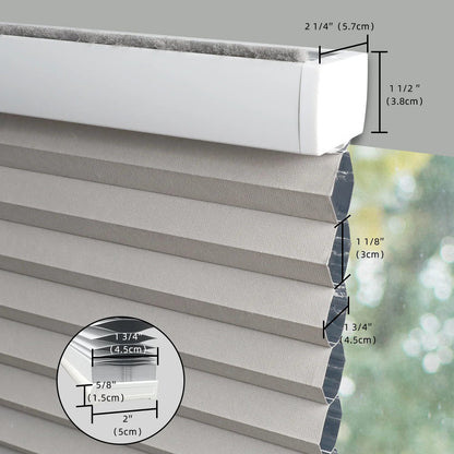 Close-up of a gray pleated window shade with overlaid dimension labels showing the width, height, and pleat thickness, plus a circular inset detail of the fabric layers.