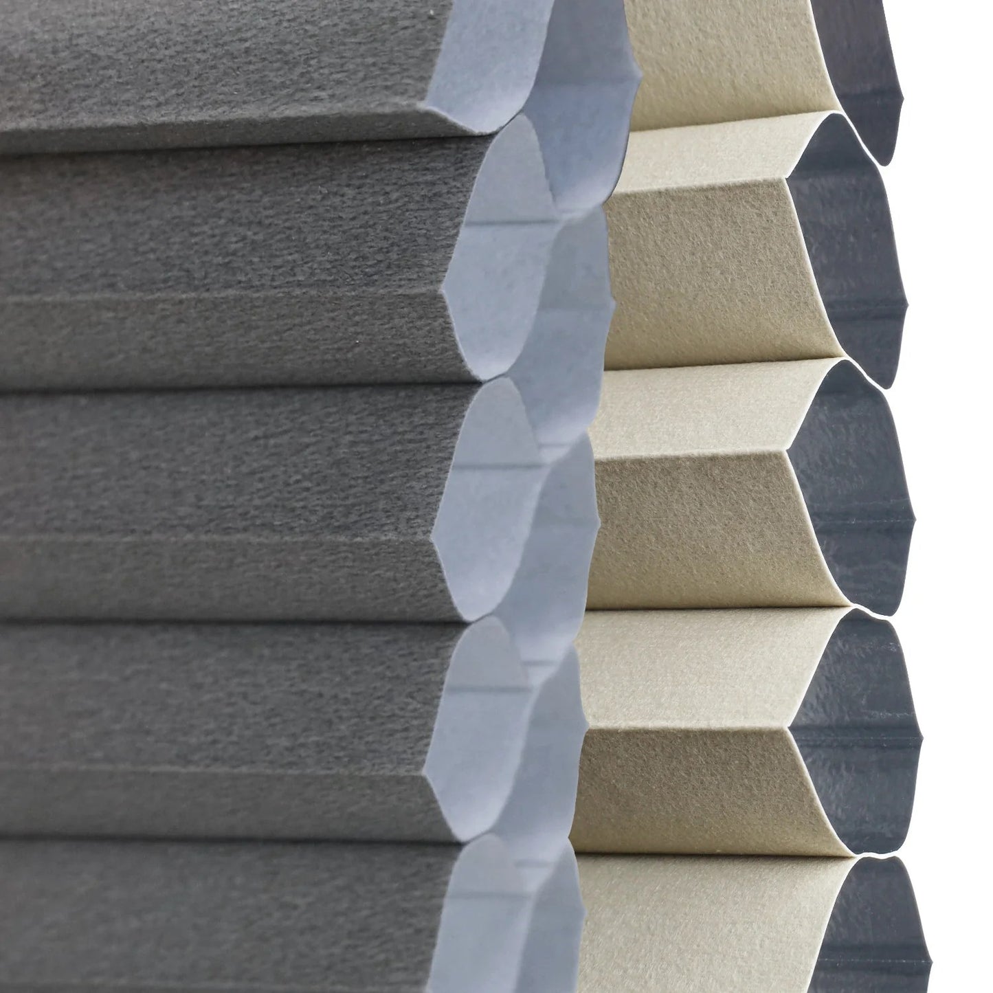 Close-up of hexagonal foam panels in two colors: dark gray on the left and light beige on the right, showing their textured surfaces and layered structure.