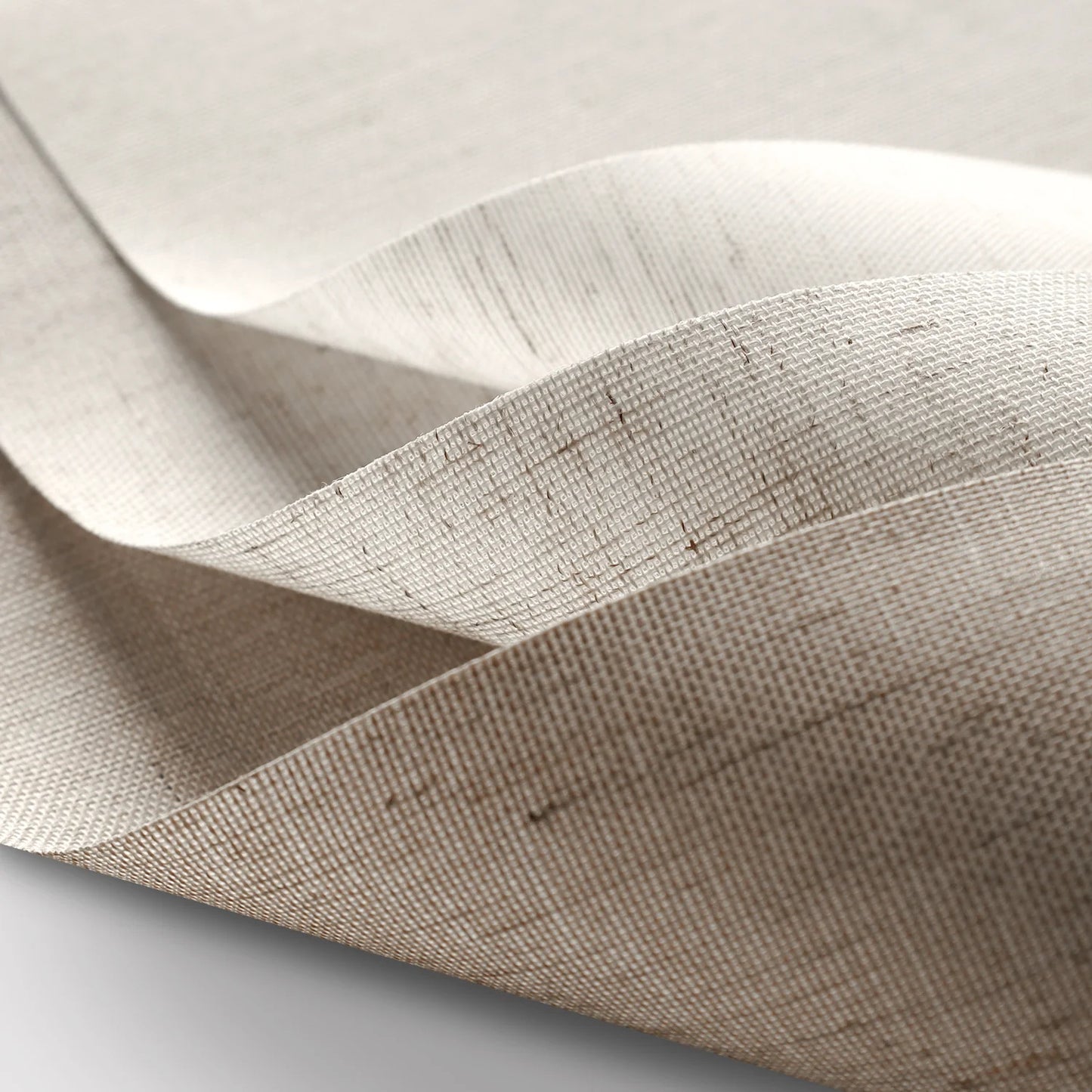 Close-up of beige fabric with a subtle pattern on a light gray background