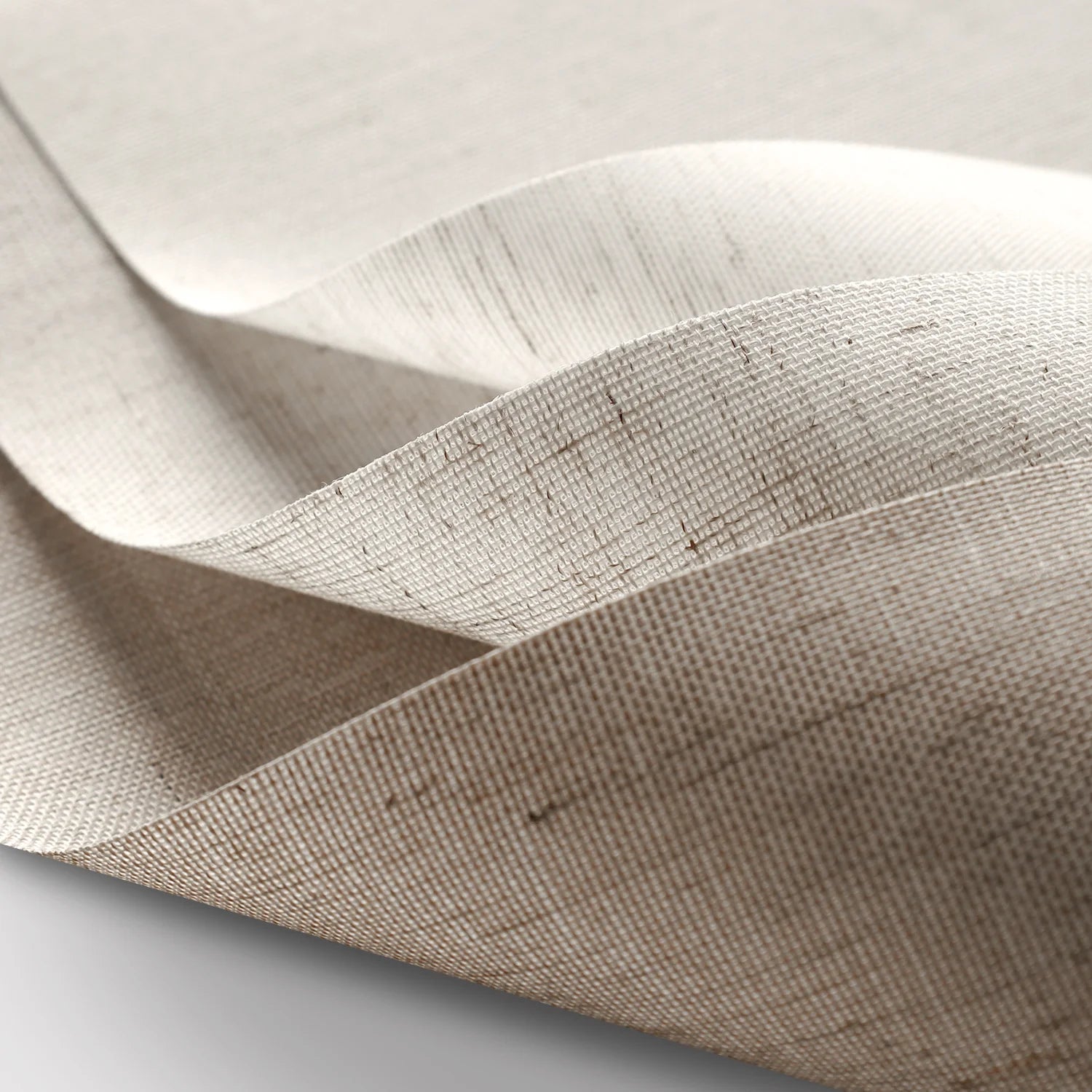 Close-up of beige fabric with a subtle pattern on a light gray background