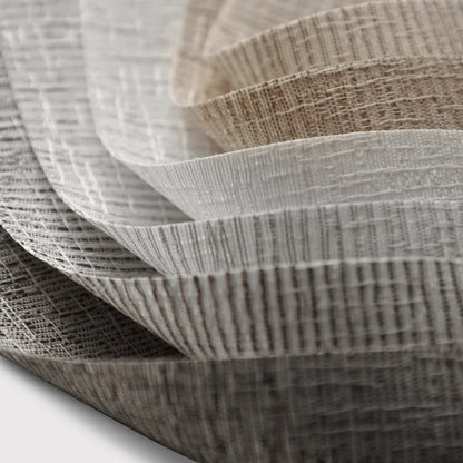 Stack of textured fabric sheets in various colors on a light gray background