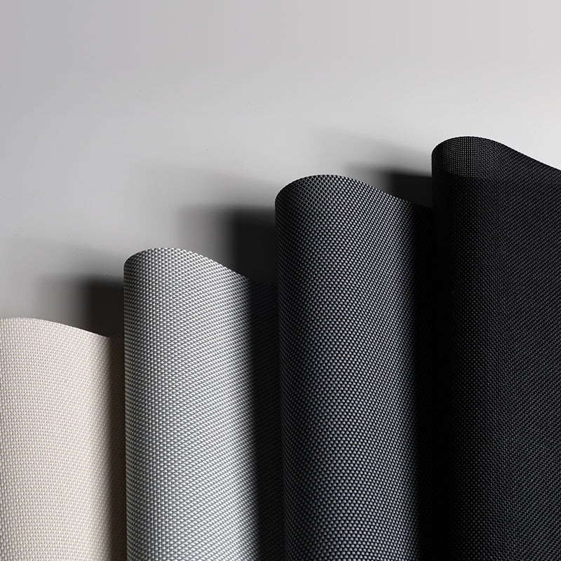 Three rolls of fabric with different textures on a gray background