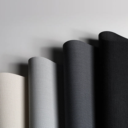 Three rolls of fabric with different textures on a gray background